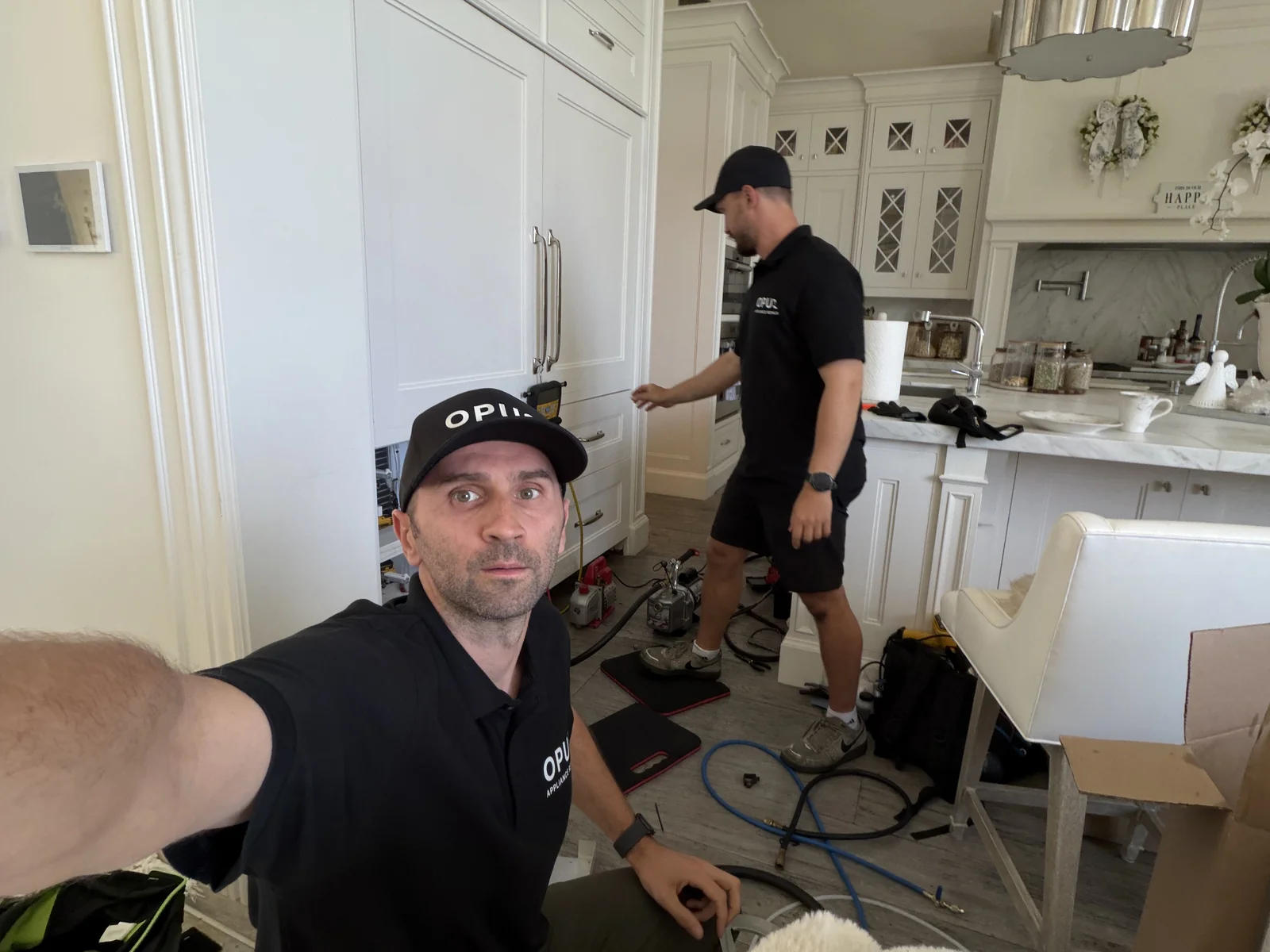 OPUS technicians Andrew and Yurii replacing a refrigerator compressor in San Diego